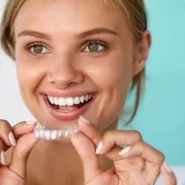 Smiling Woman With Beautiful Smile Using Teeth Whitening Tray. High Resolution Image